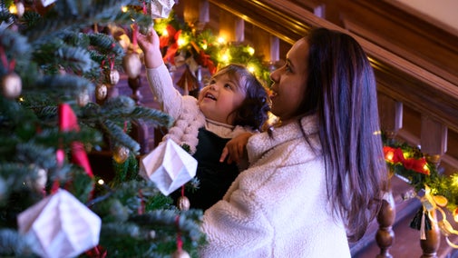 A woman and young child looking at a Christmas tree close up, Dyrham Park, South Gloucestershire